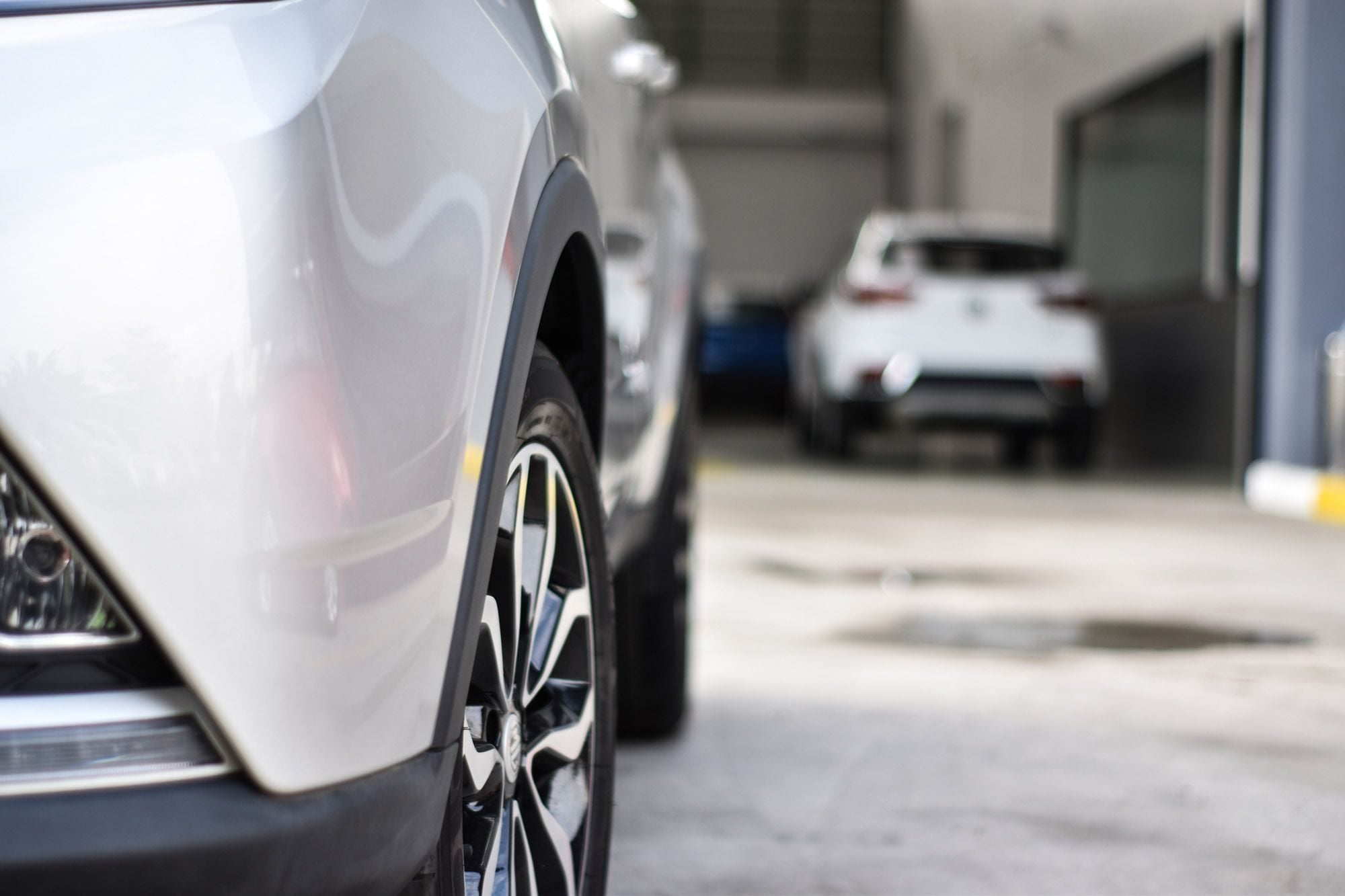 Utsnitt av panser og det ene hjulet på en bruktbil