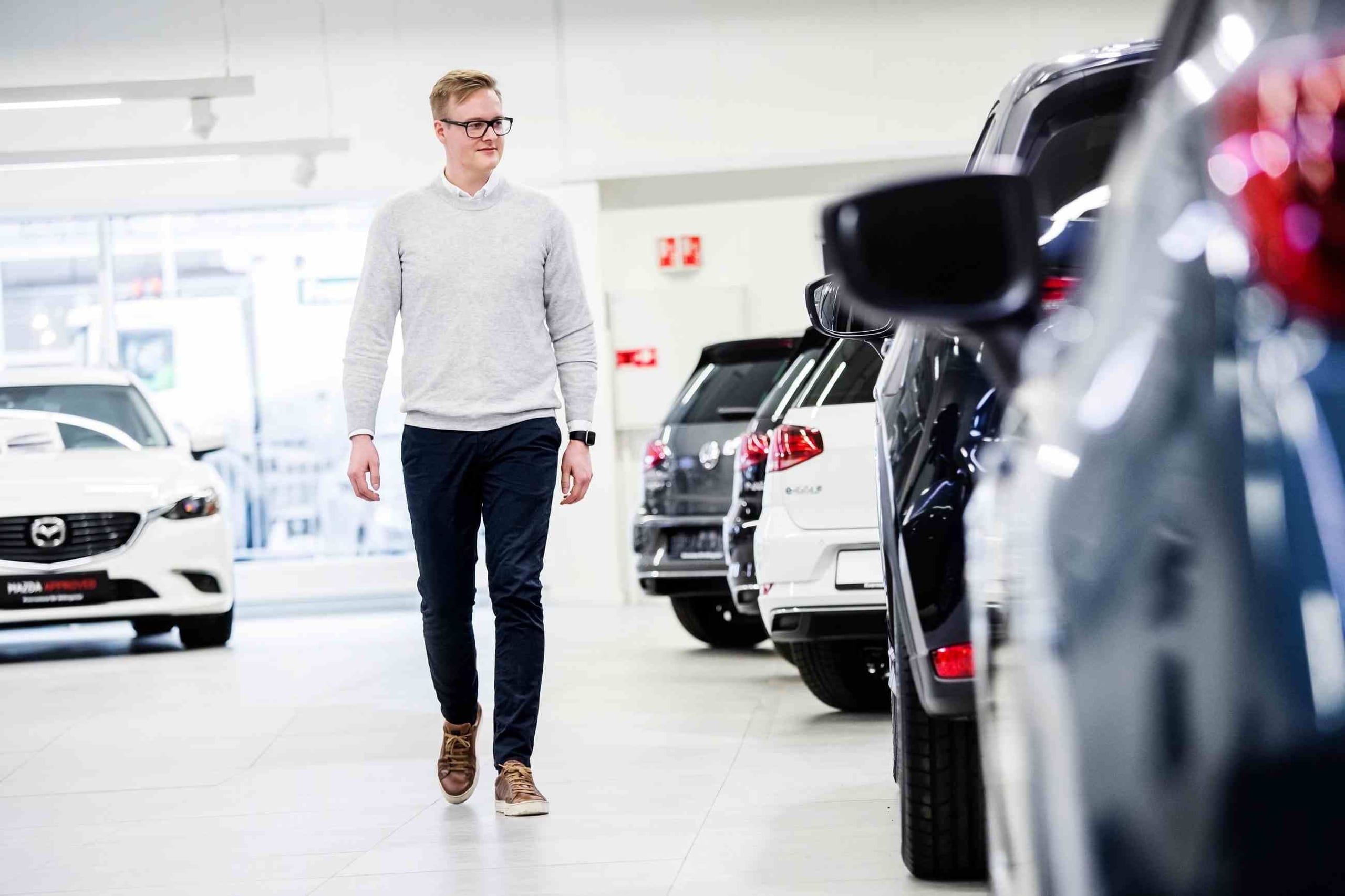 Mann som ser på bruktbiler hos forhandler