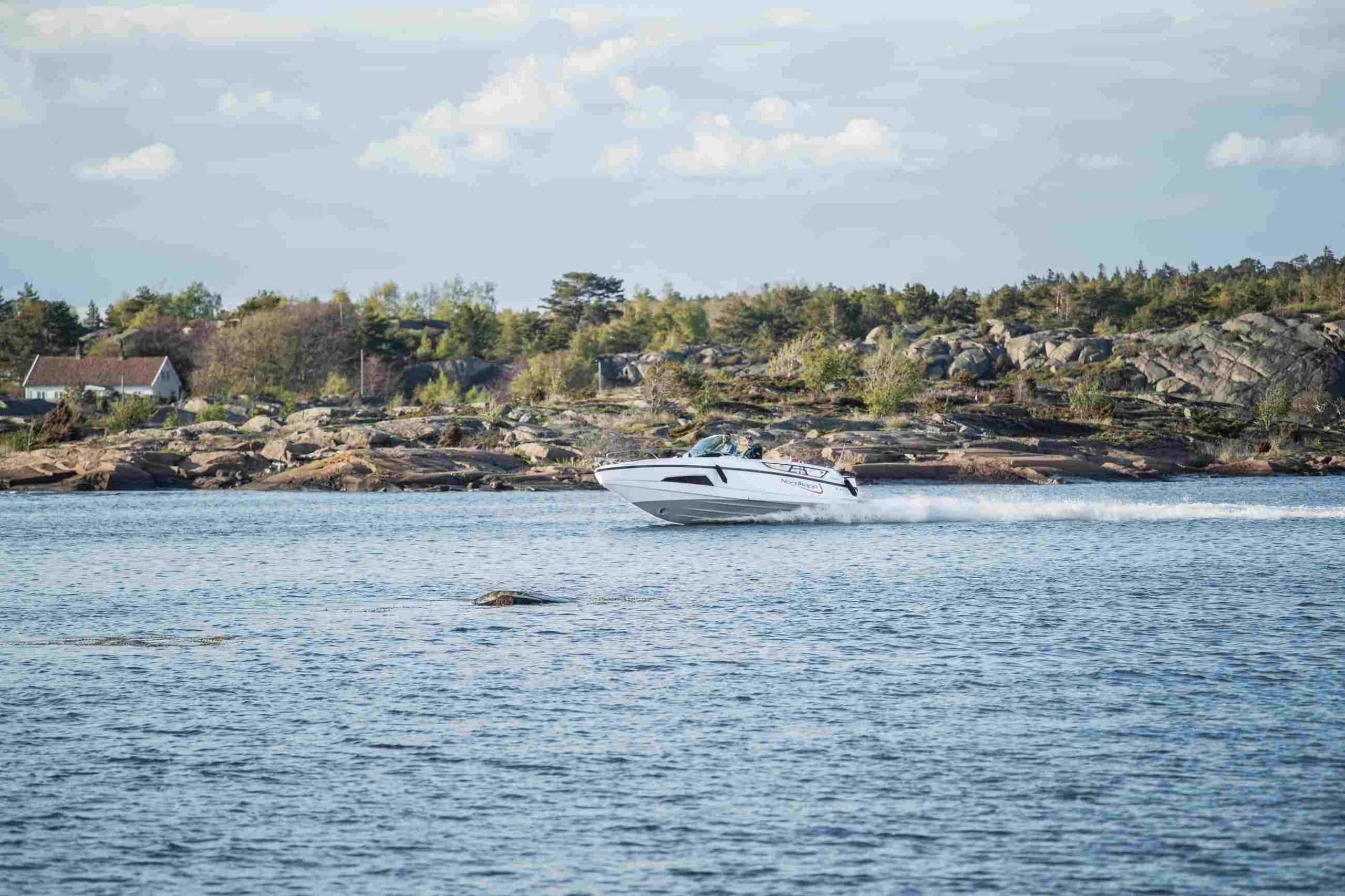 Sporty landsstedsbåt, Tha 9328-27, i fart i skjærgården